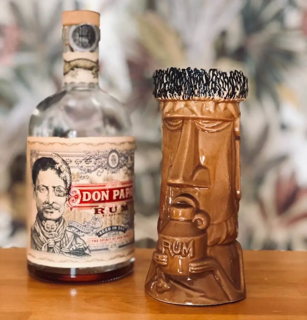 Bottle of don papa rum brands with moai rum brands mug.