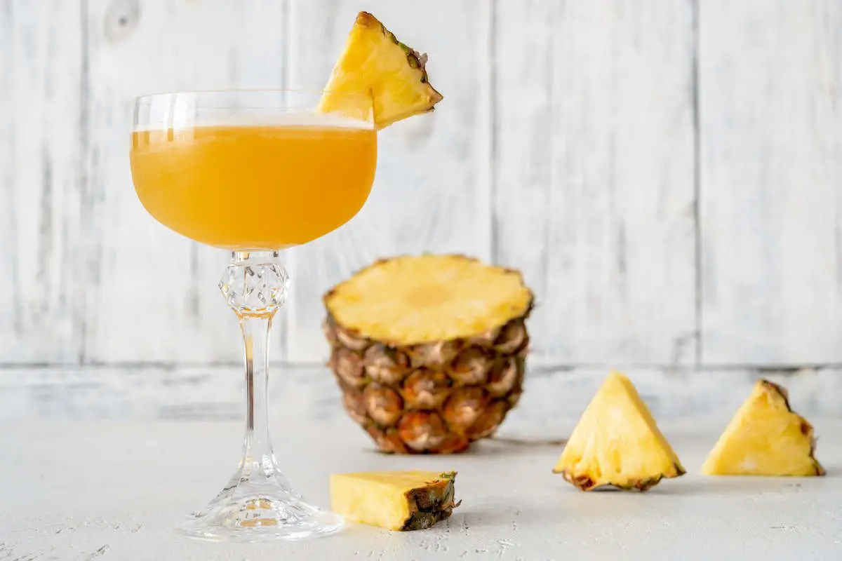 Algonquin cocktail with pineapple in coupe glass