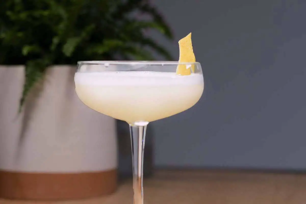 White lady cocktail in coupe glass with lemon peel garnish